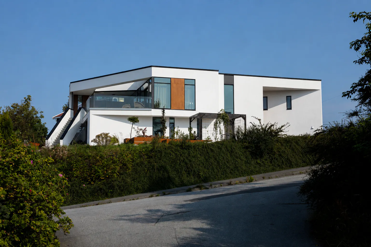 Moderne Urbanhus med rene linjer, flatt tak, utvendig trapp og store glassflater som slipper inn godt med dagslys.